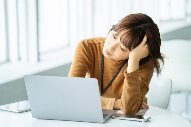 パソコンの前で困っている女性